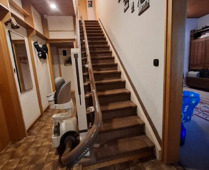 Treppenlift in einem Flur mit Holztreppe